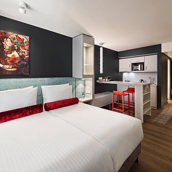 Modernes Hotelapartment mit Doppelbett und Küchenzeile
