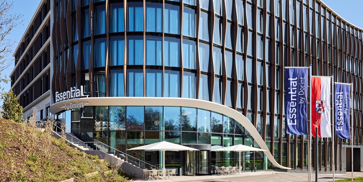 Wellenartige Glasfassade eines Dorint Hotelkomplexes mit Flaggen im Vordergrund